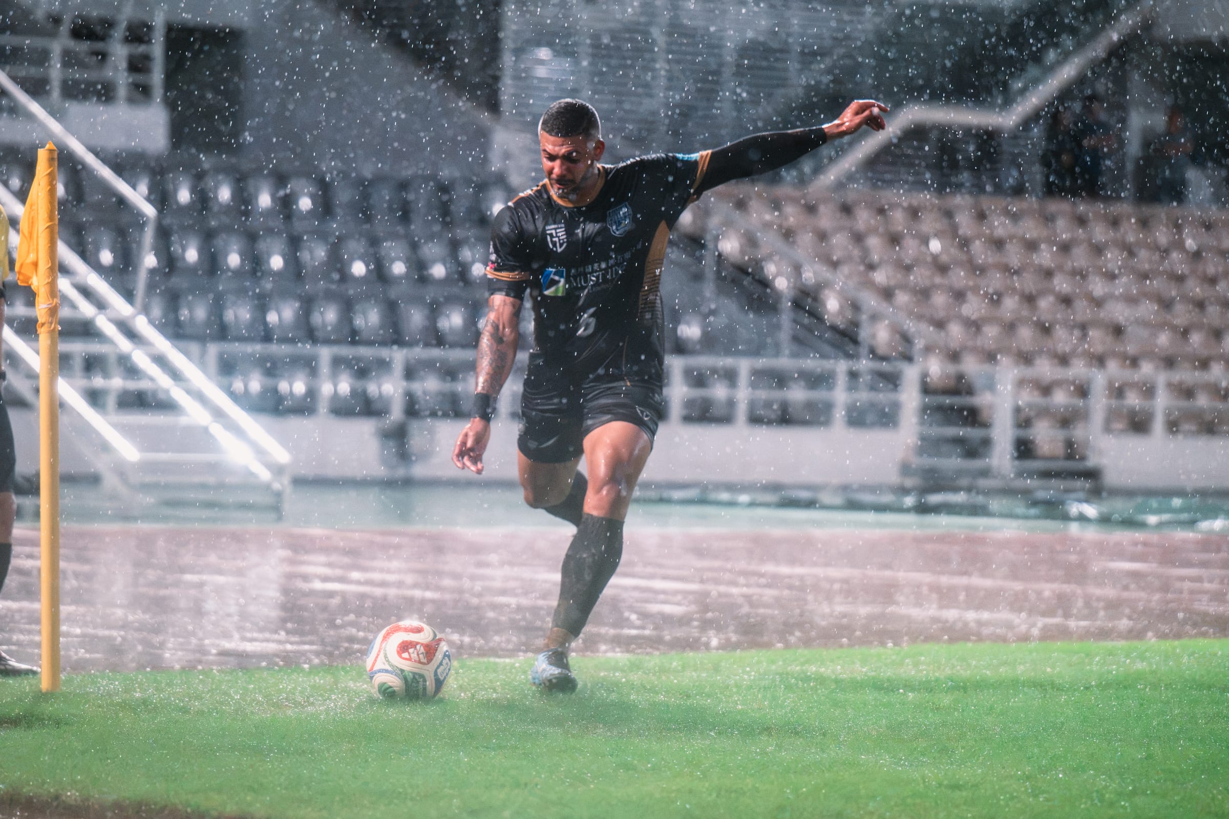 Jogador da equipa principal do MUST IPO a marcar um canto sob chuva intensa